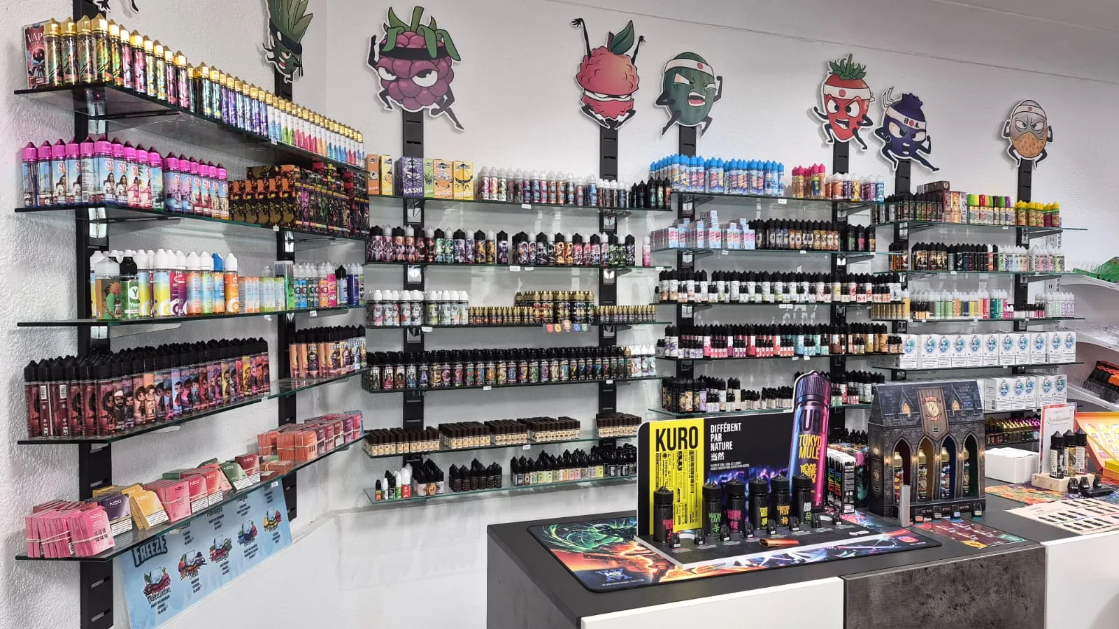 Intérieur de la boutique RoyalCig Nay avec rayonnages d'e-liquides et matériel de vape